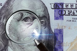 magnifying glass enlarges detail on a dollar bill